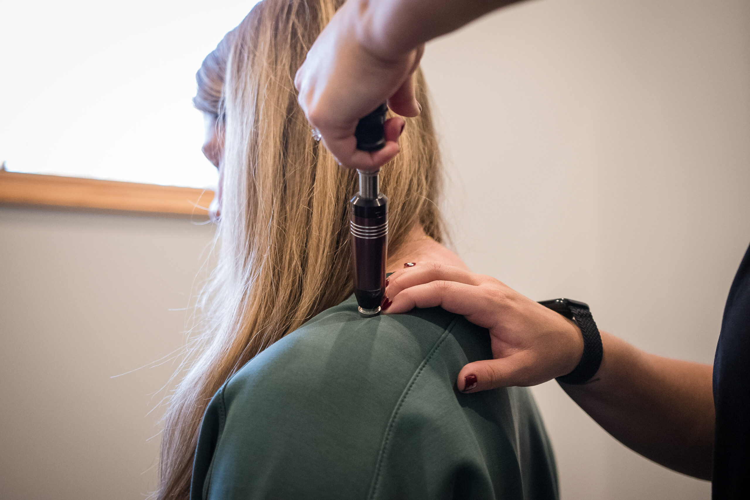 Activator Technique adjustment on patient's shoulder at Skelly Chiropractic