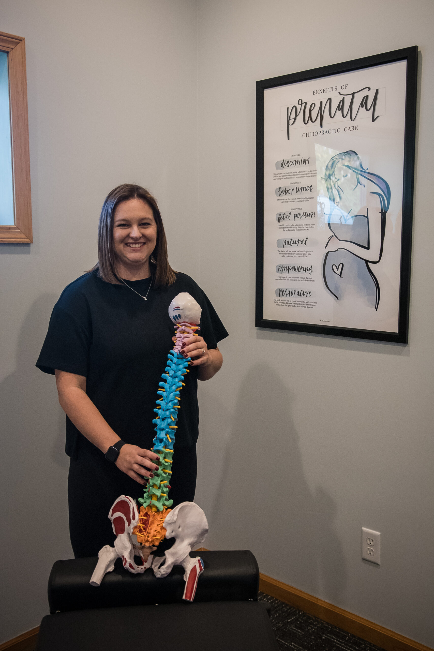 Dr. Kacey Skelly holding spine model for Webster Technique and pregnancy chiropractic care.