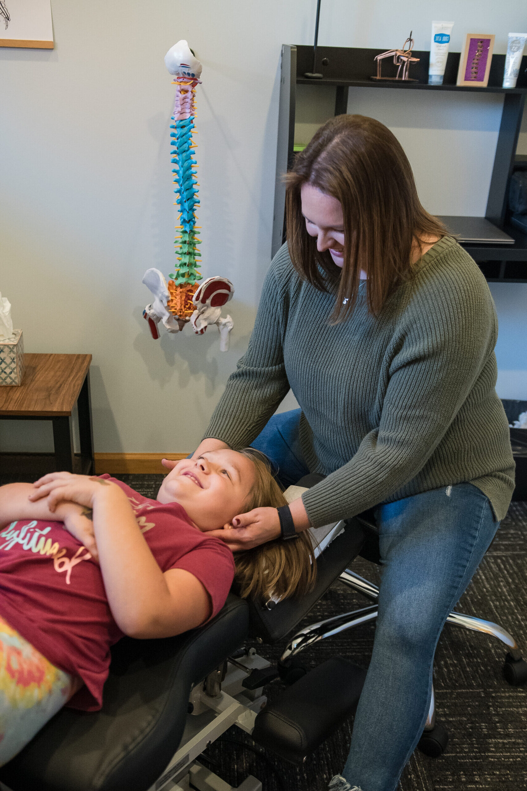 Dr. Kacey Skelly providing chiropractic care to a young patient for family care offered.